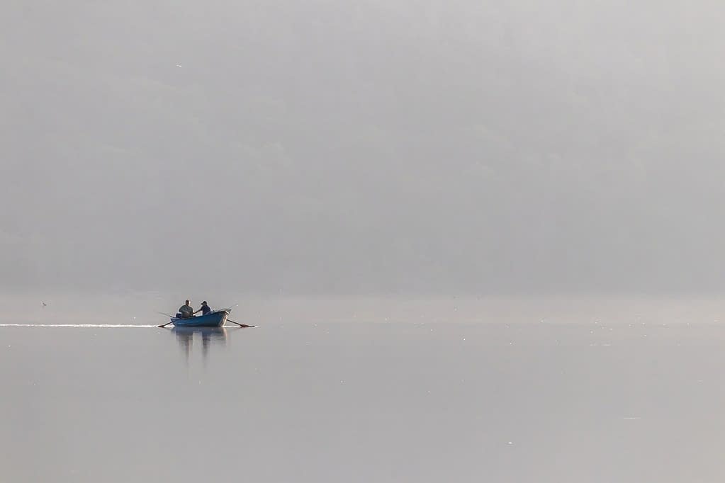 Boat on early morning lake representing the writer's journey